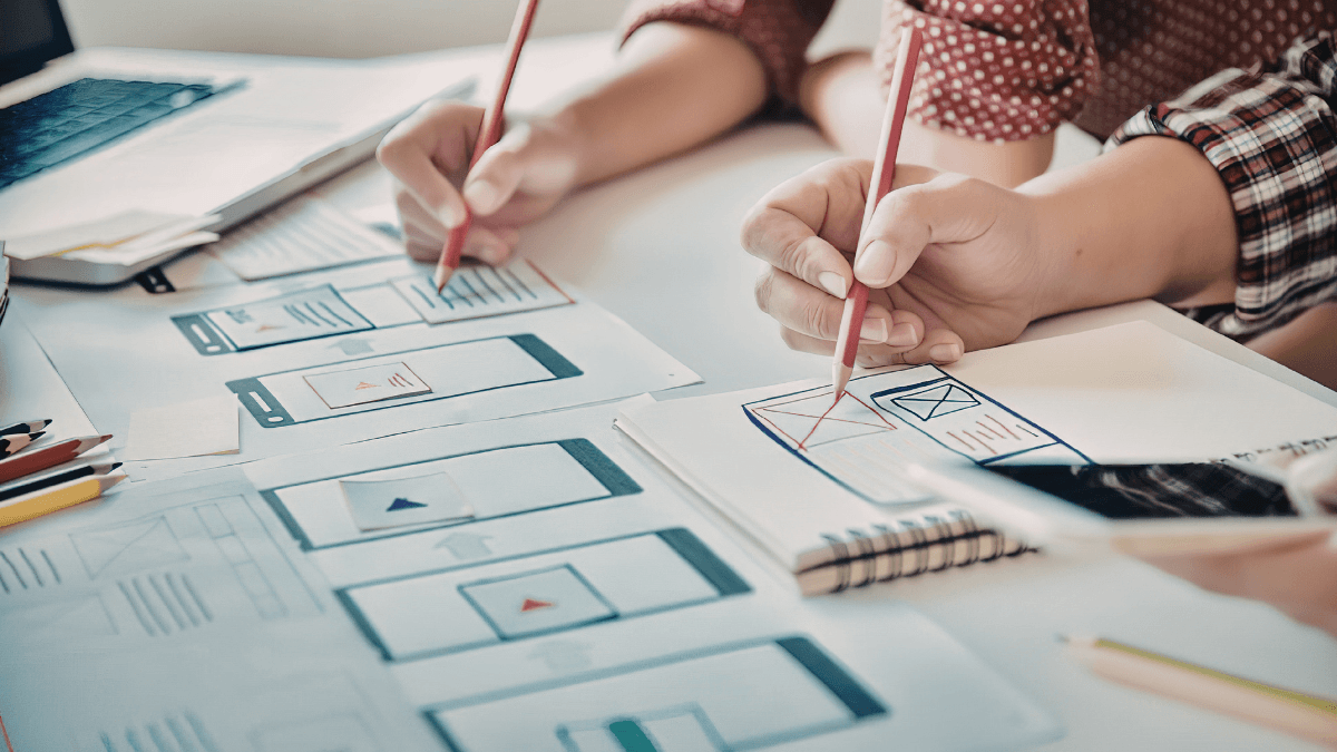 Small business website page planning on a desk with laptop and notes